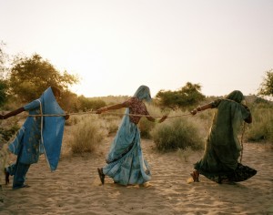Title: Pulling of the well, Tharpakar, Pakistan, 2013. Caption: Women of Tharpakar in the southern Sindh Province of Pakistan work together to pull water from a well. Even when one person is done, they all remain at the well to share in the task. One of the effects of the flooding was salinity in the ground, which affected the ability for the agricultural region to support itself. The water gathered is brackish and dangerous to the health of children, who often suffer diarrhea and other water-borne illnesses. Tharpakar, Pakistan, 2013.