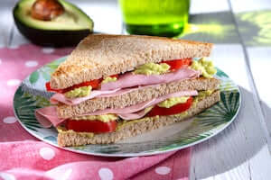 tramezzino-di-pane-integrale-con-crema-di-avocado-prosciutto-cotto-e-pomodori